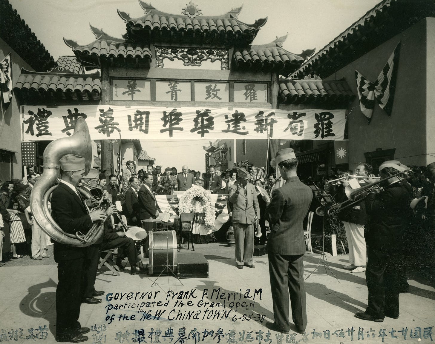 black and white photo of a military band playing in front of a Chinese gate at New Chinatown