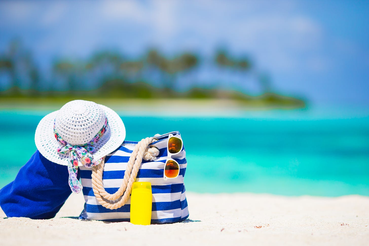 Beach bag, hat, sunglasses on the sand