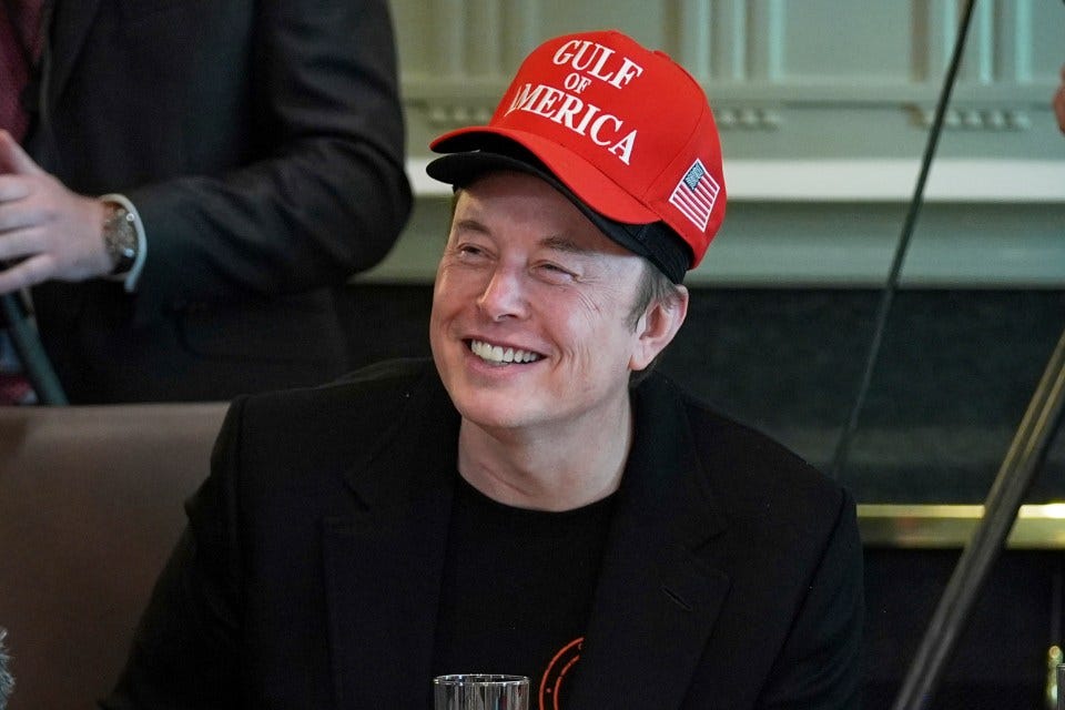 Elon Musk at a White House cabinet meeting wearing a "Gulf of Merica" hat.