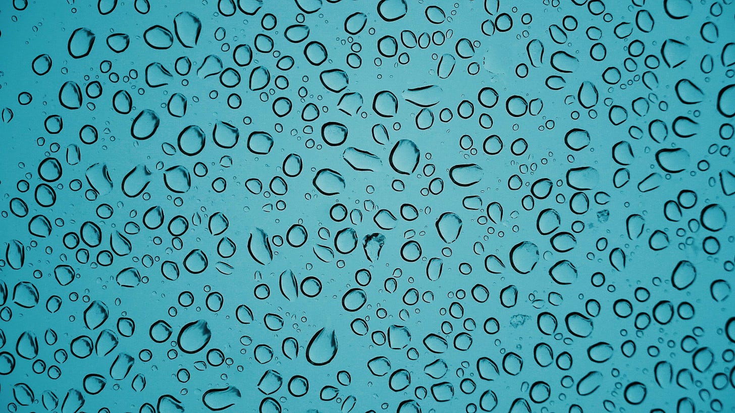 gocce di acqua su una superficie trasparente sfondo azzurro
