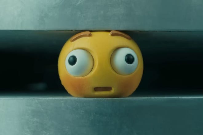 A yellow toy face being squashed until it's bug-eyed