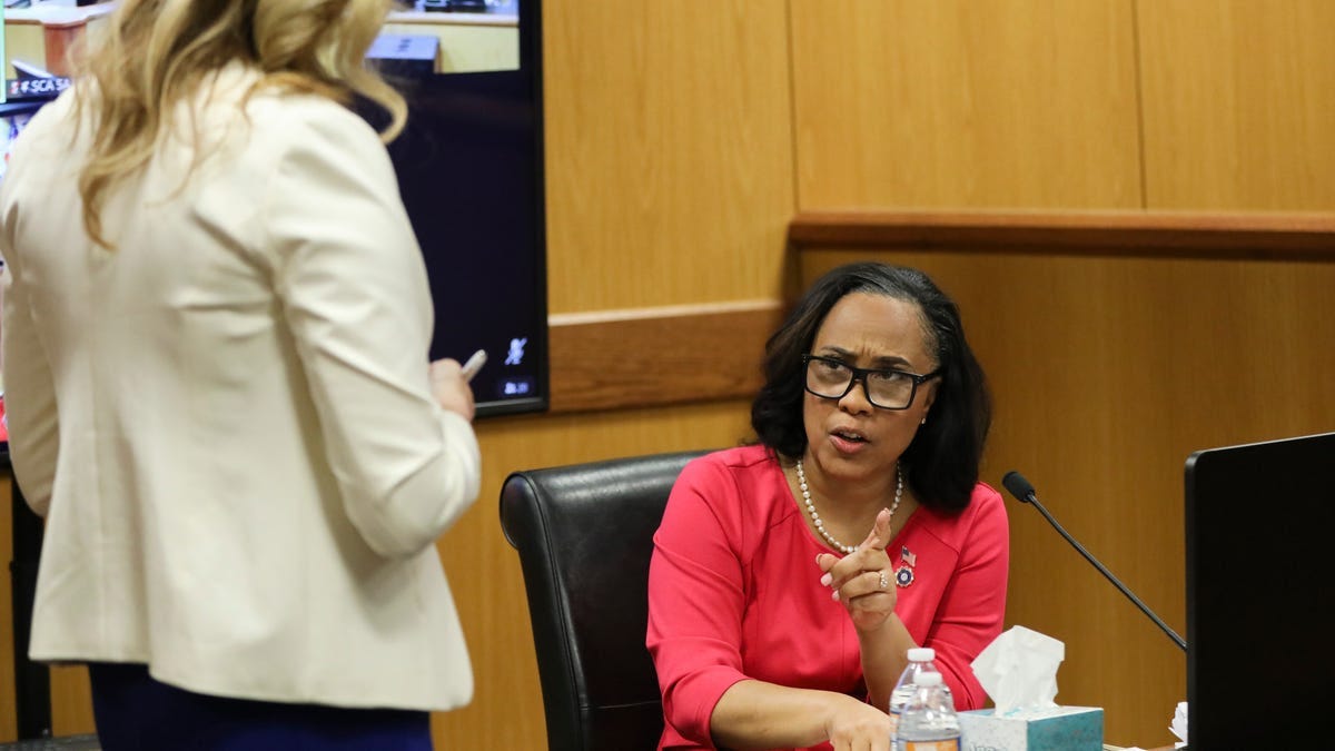 Attorney Fani Willis speaks while holding documents during a hearing in the case of State of Georgia v. Donald John Trump at the Fulton County Courthouse in Atlanta, Georgia, U.S., February 15, 2024.