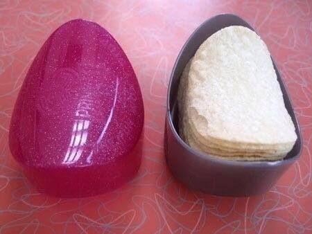 A 90s Pringle holder. It's a tiny plastic container in the shape of a stack of Pringles; they fit perfectly inside. The bottom of this one is gray and the top is pink clear glitter.