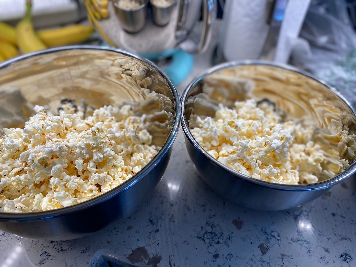 Picture of two metal bowls with popcorn in them