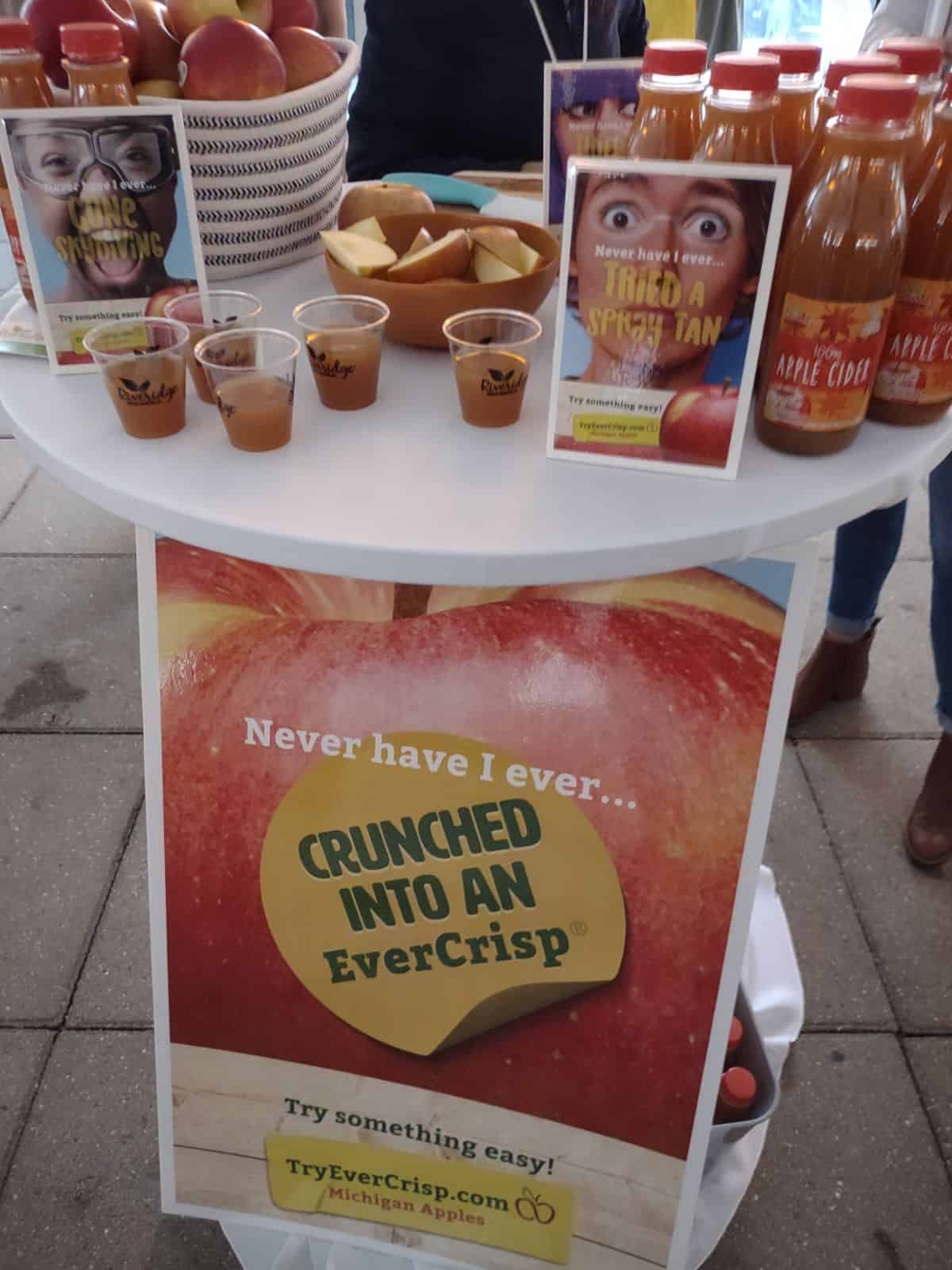 A table at a conference talking about Evercrisp apples with samples.