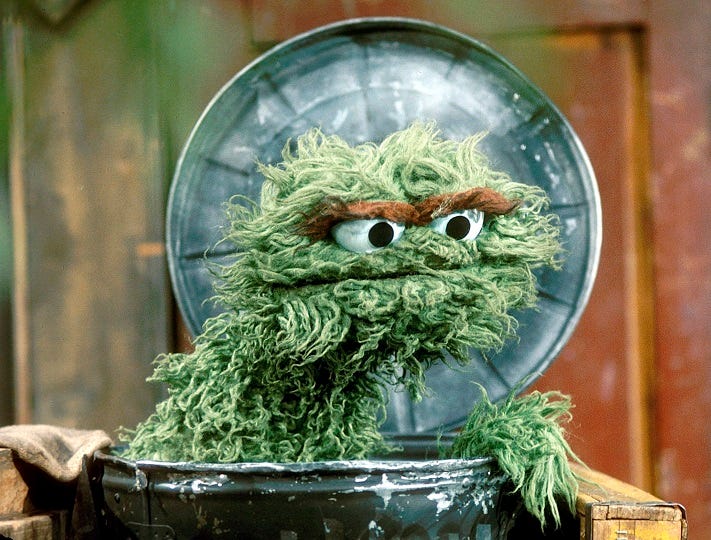 Oscar the Grouch in his can looking annoyed