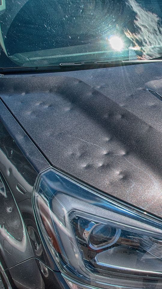 truck with hail damage dents on hood