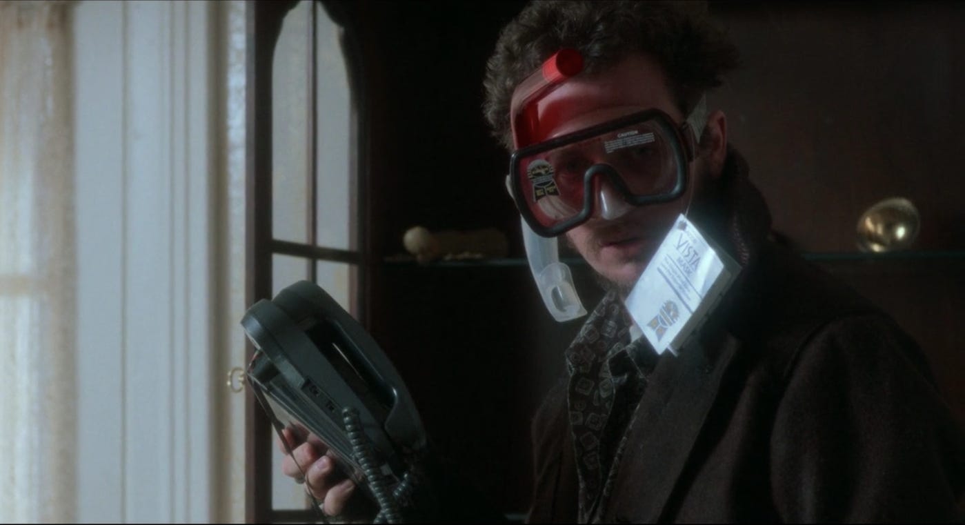 Marv in Home Alone, as played by Daniel Stern. He is robbing a house, holding a phone while wearing snorkelling gear on his head