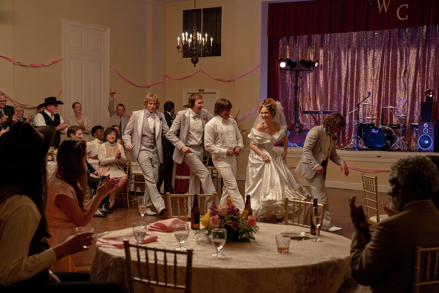 Still from “The Iron Claw” depicting five people linedancing at a wedding.