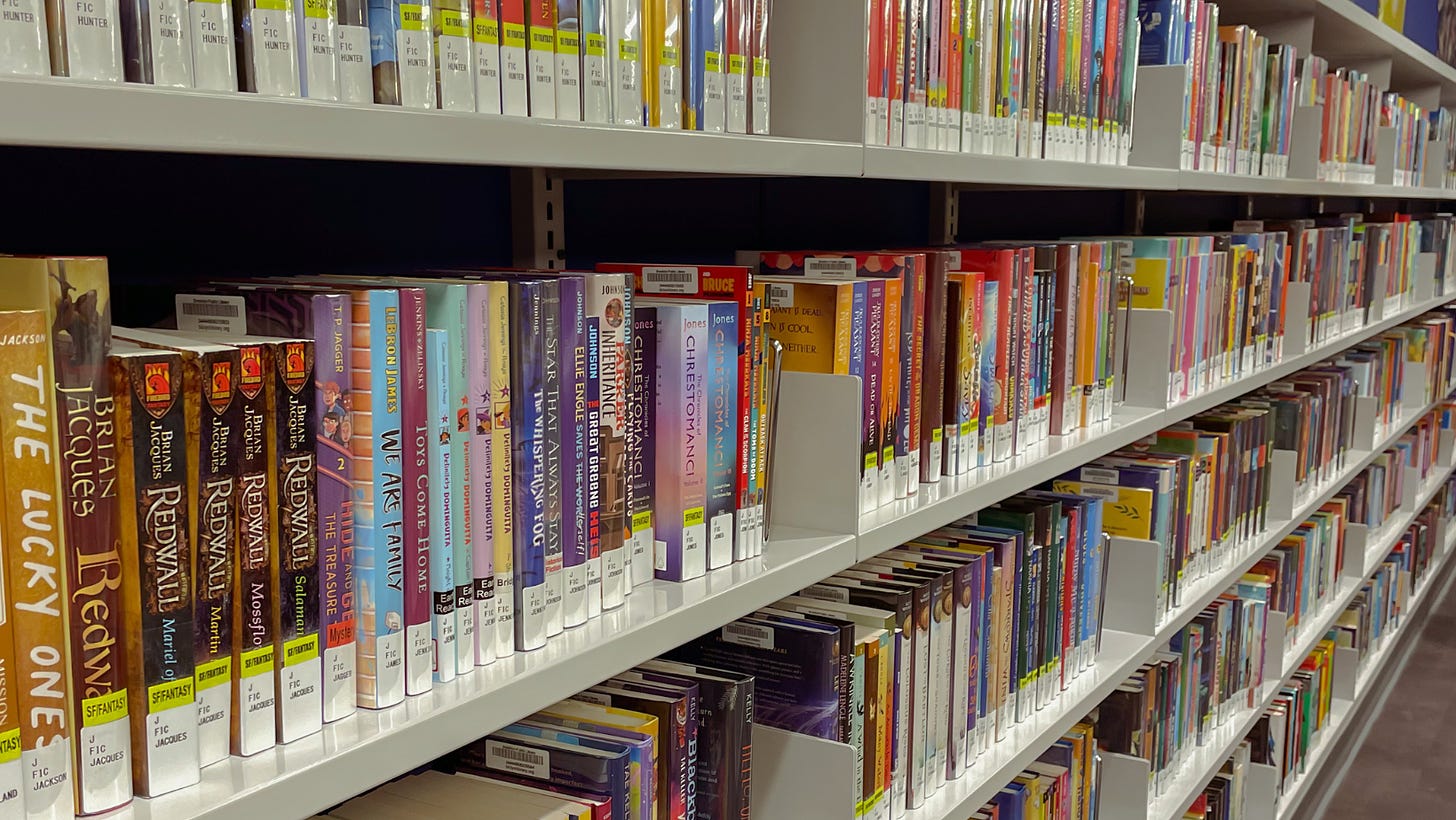A long library shelf of Middle Grade books at a public library.