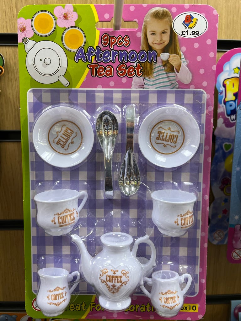 A cheap child's toy tea set. The packaging describes it as '9pcs Afternoon Tea Set'. However, seven of those nine pieces are decorated with the word 'COFFEE' in capital letters. And the other two are spoons. 