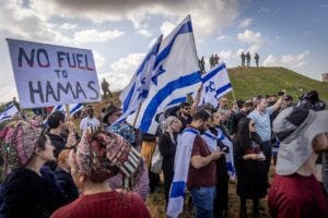 Israelis protest against aid trucks entering the Gaza Strip at the Kerem Shalom border crossing, Jan. 29, 2024. Military personnel are visible at the top of the hill, but are not stopping the protest