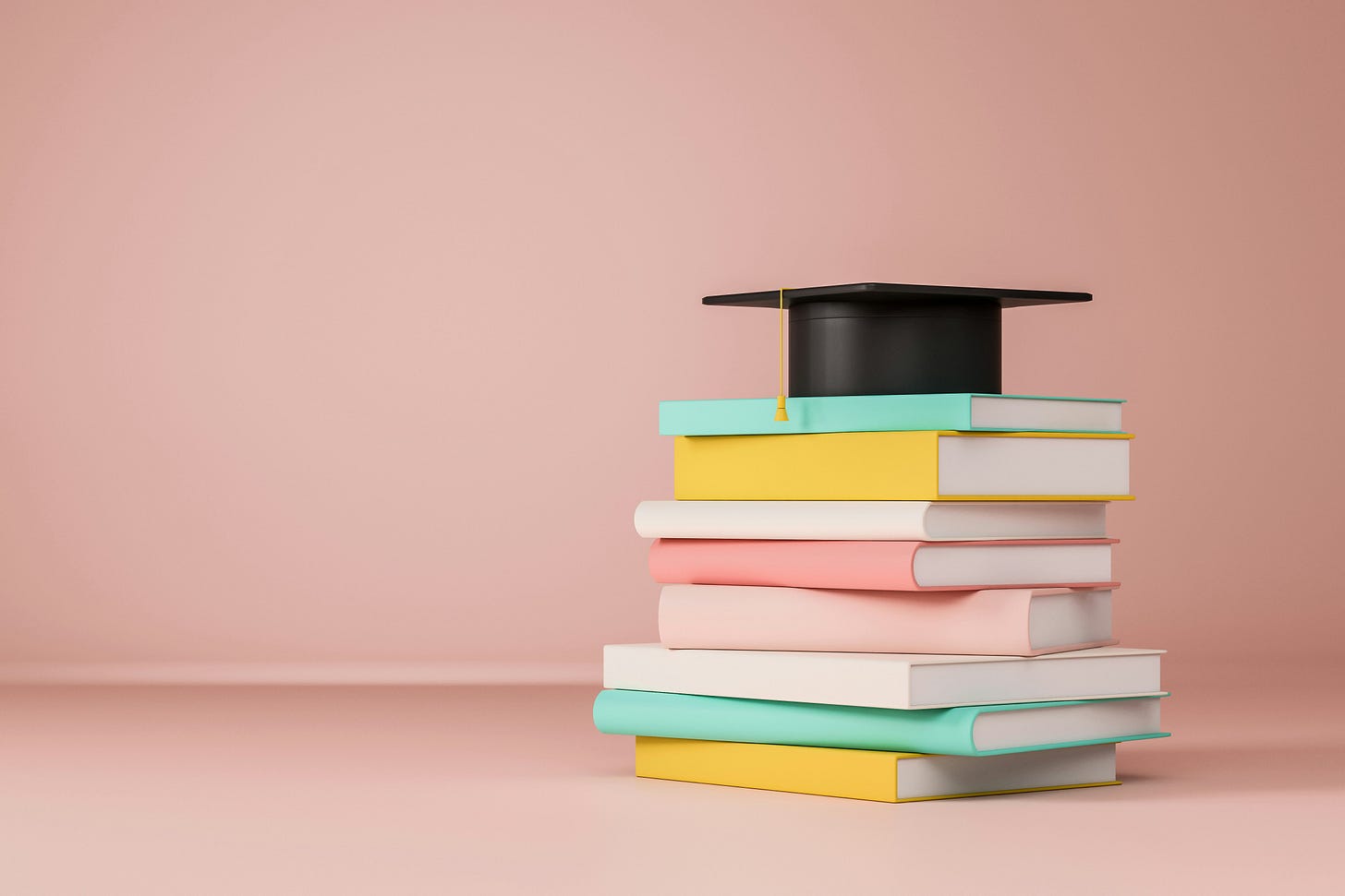 stack of books with graduate cap on top