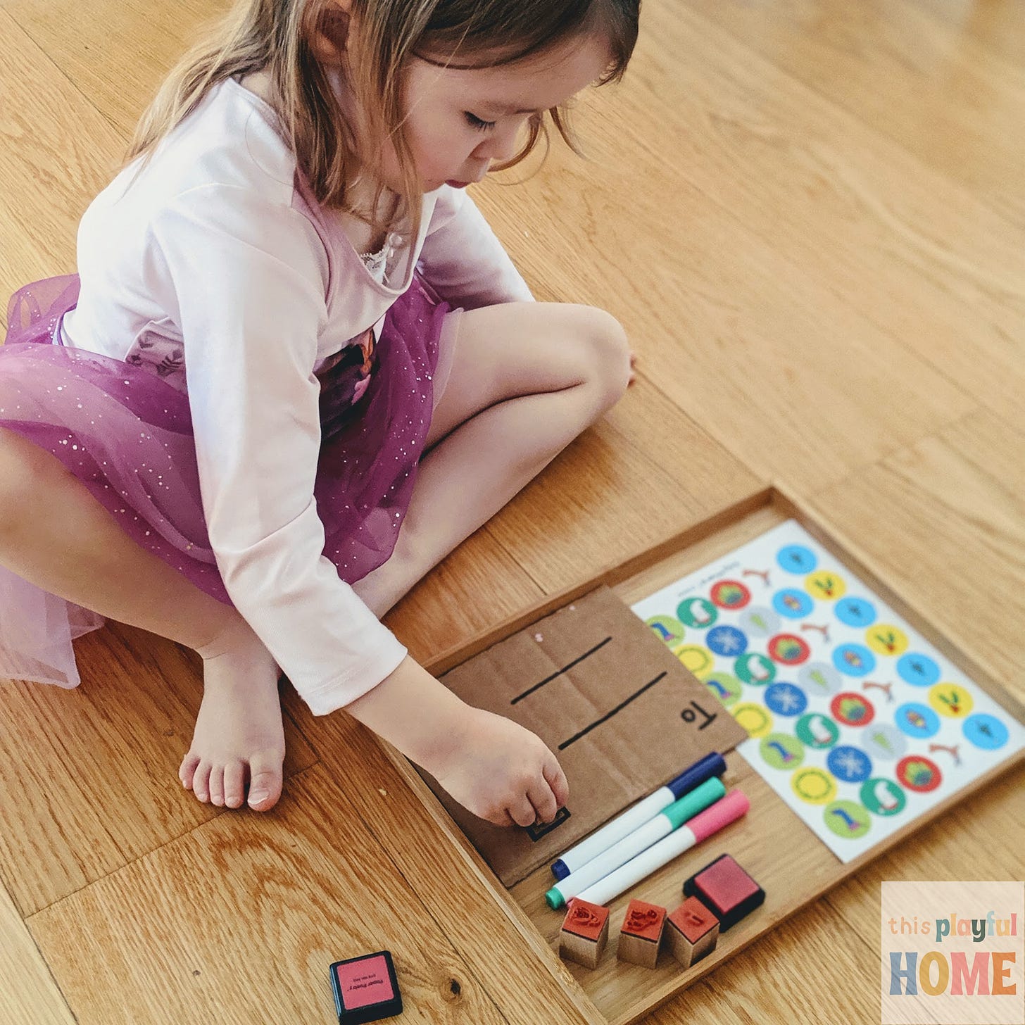 a 4 year old girl places stamps onto a pretend letter