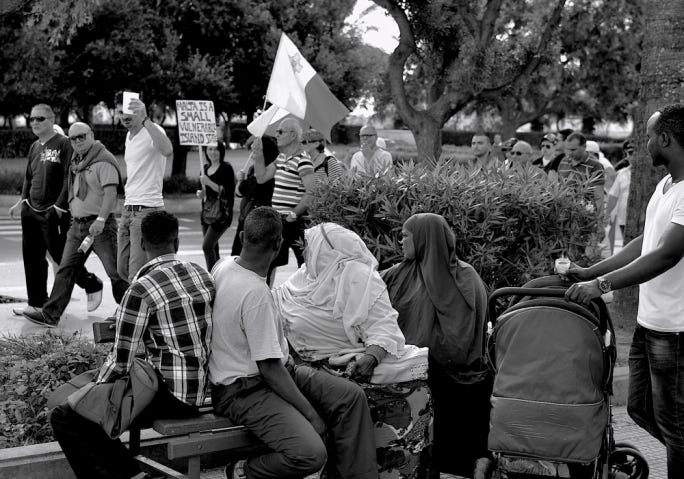 Far-right march by the Patriots Movement. A migrant family looks on