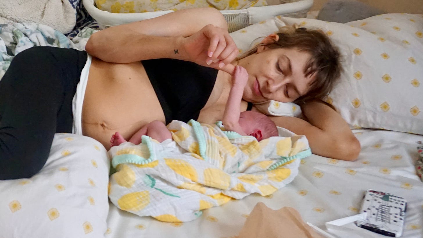 Rebekah lies on her side next to her new baby. He is wrapped in a blanket, holding onto her thumb. You can see her belly, still stretched out form when he was living there, and just make out the tops of her mesh and padded, postpartum undies. Rebekah lies on her side next to her new baby. He is wrapped in a blanket, holding onto her thumb. You can see her belly, still stretched out form when he was living there, and just make out the tops of her mesh and padded, postpartum undies.