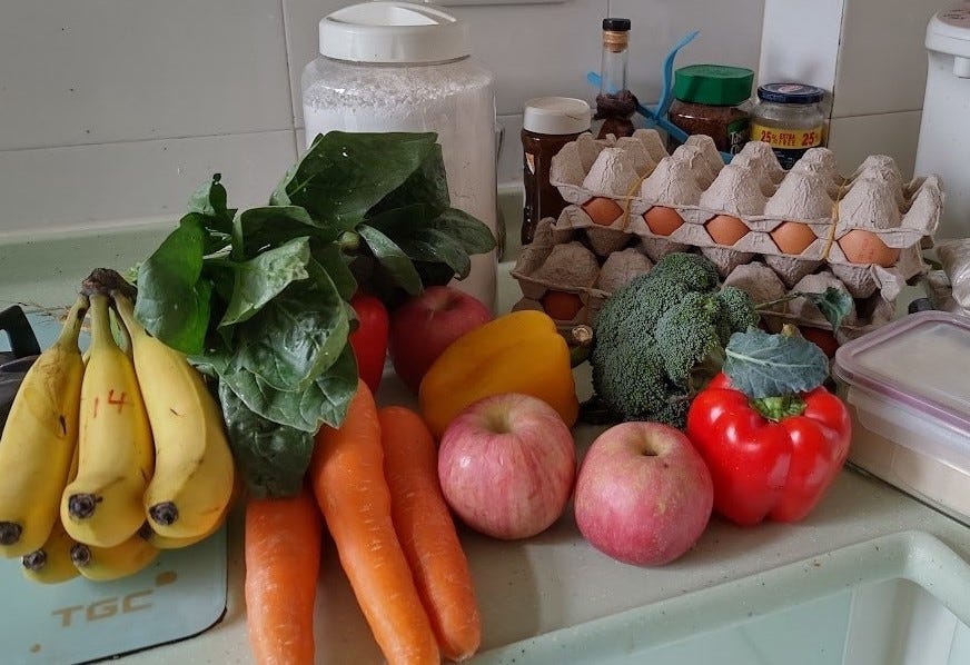 A haul of groceries on a kitchen counter (fruit, veg, eggs)