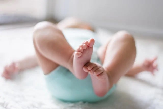 a small baby lying on the bed