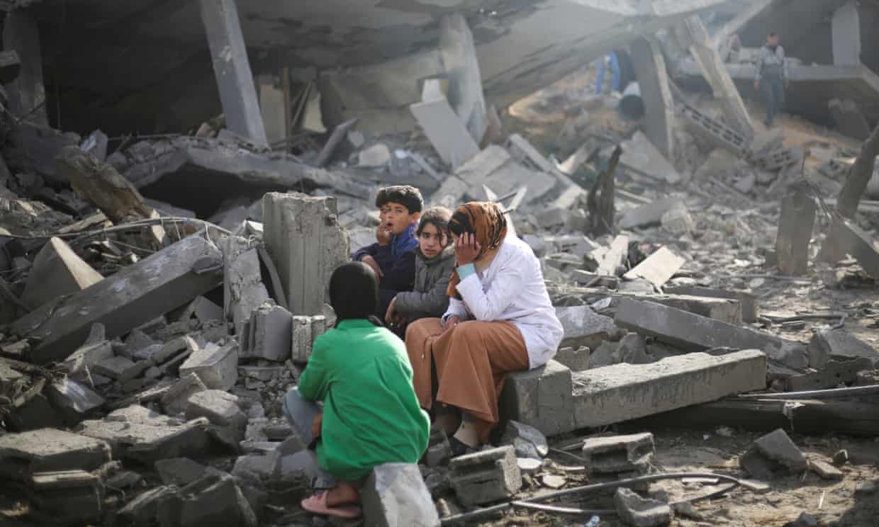 Palestinians in Rafah amid the rubble of a building destroyed by overnight Israeli bombardment