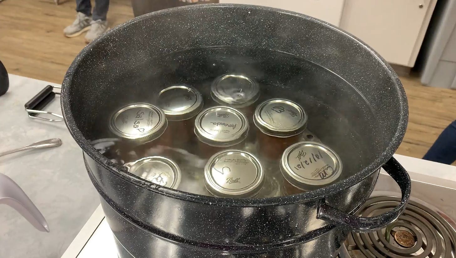 A water bath canner filled with jars