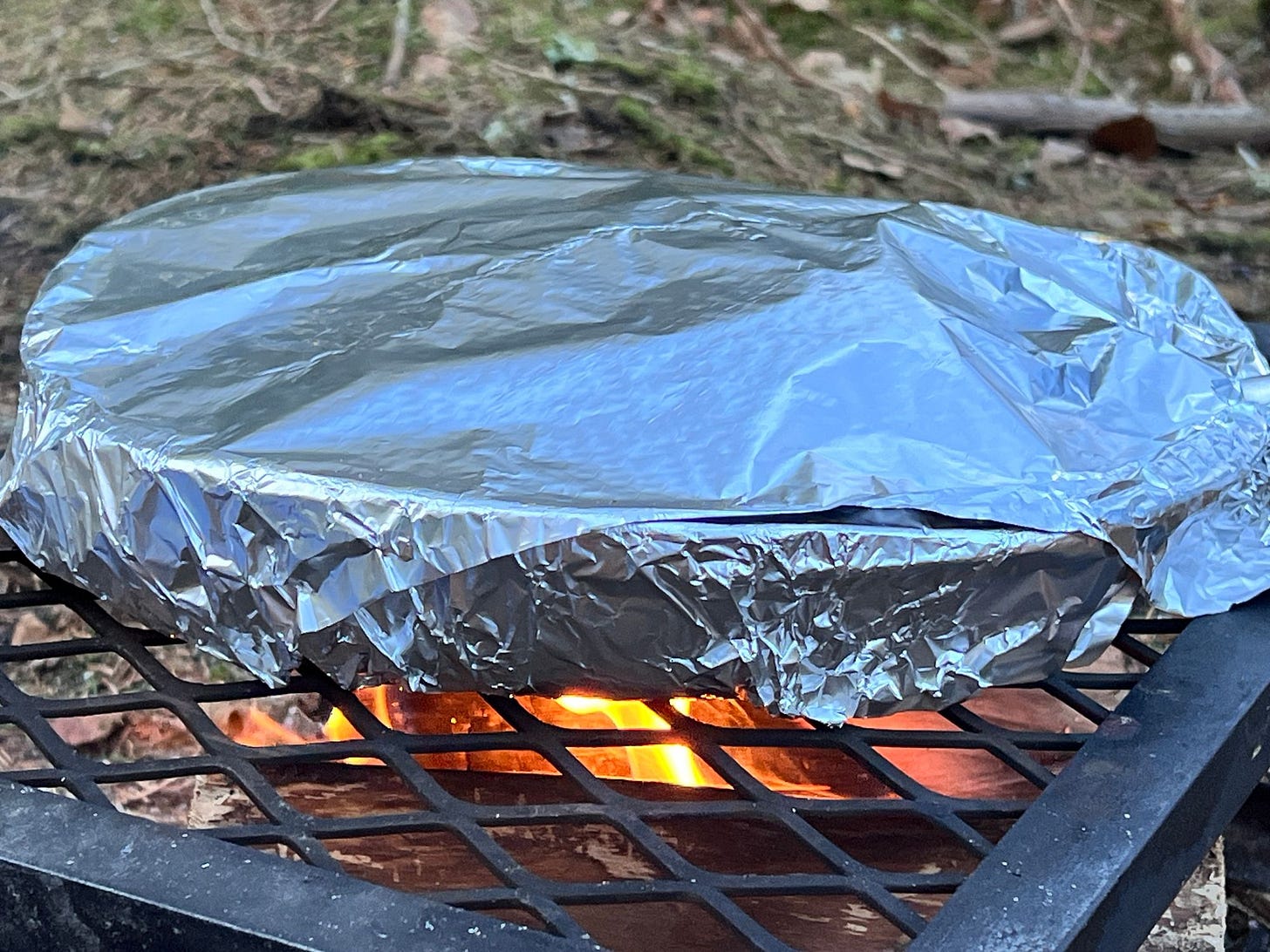 The crumble cooking with frying pan wrapped in tin foil to prevent burning and keep in the moisture