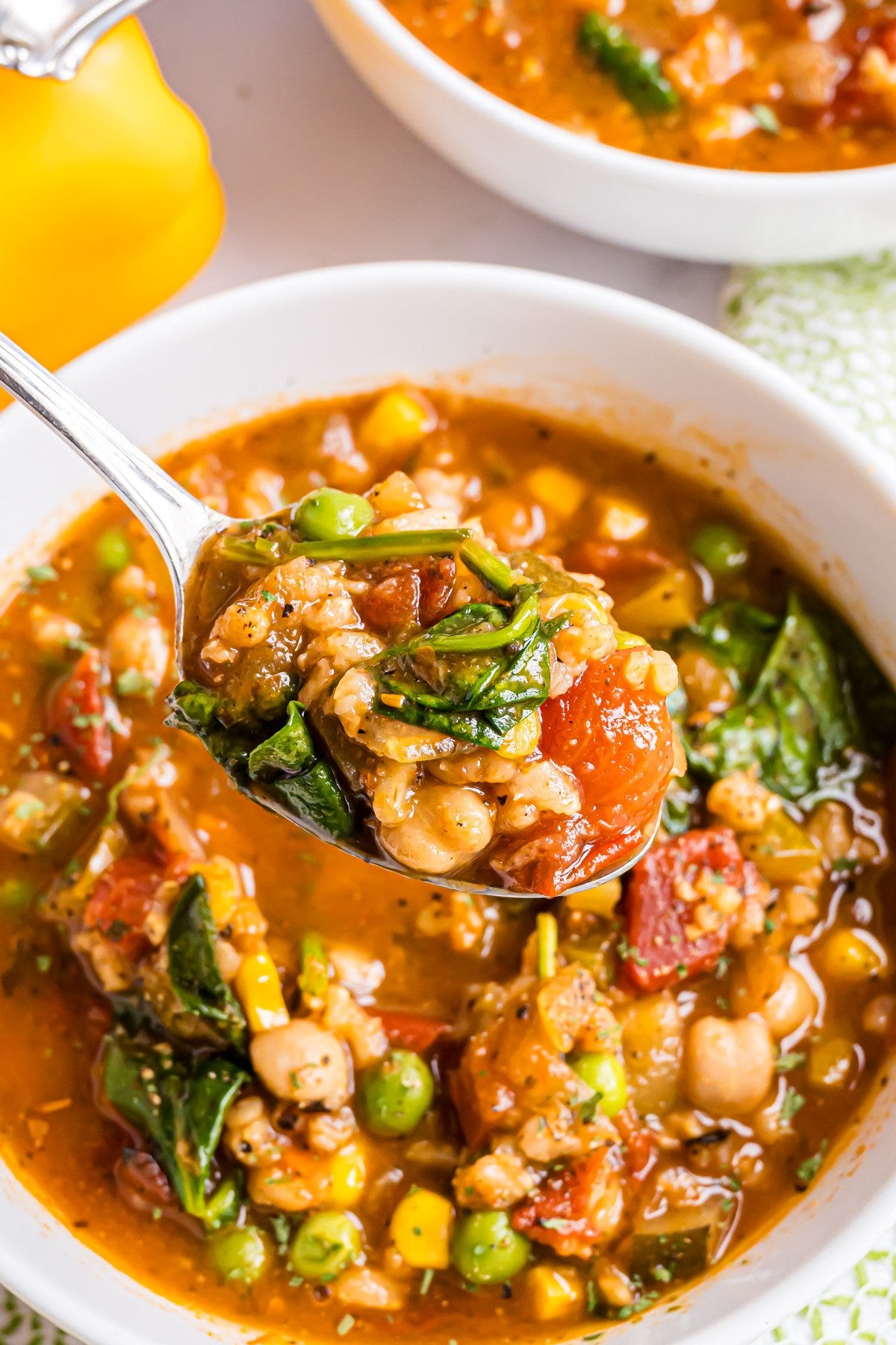 A spoon full of vegetable soup.