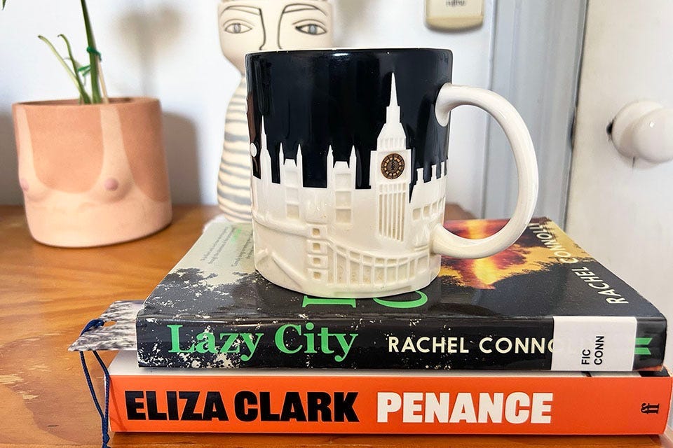 Lazy City by Rachel Connolly and Penance by Eliza Clark, under a large mug with the London skyline on it.