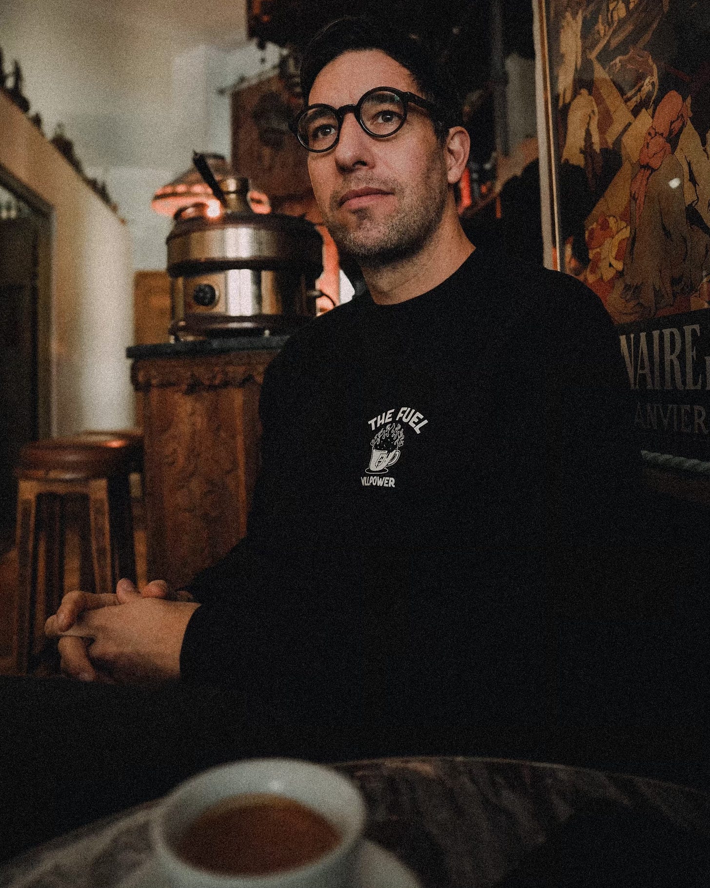 The author wearing glasses drinking espresso