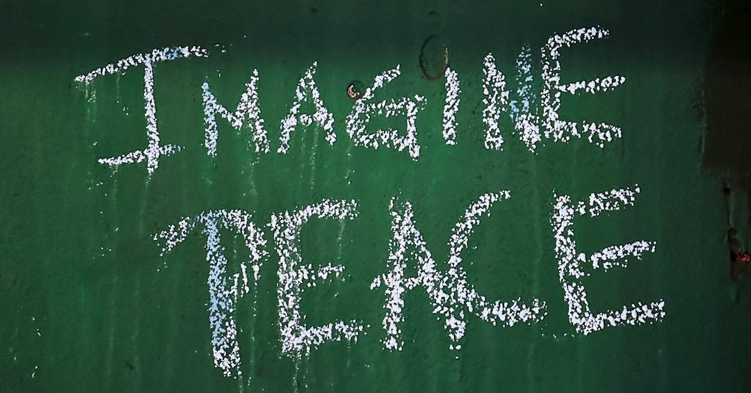 a chalk drawing on a green wall that says imagine peace