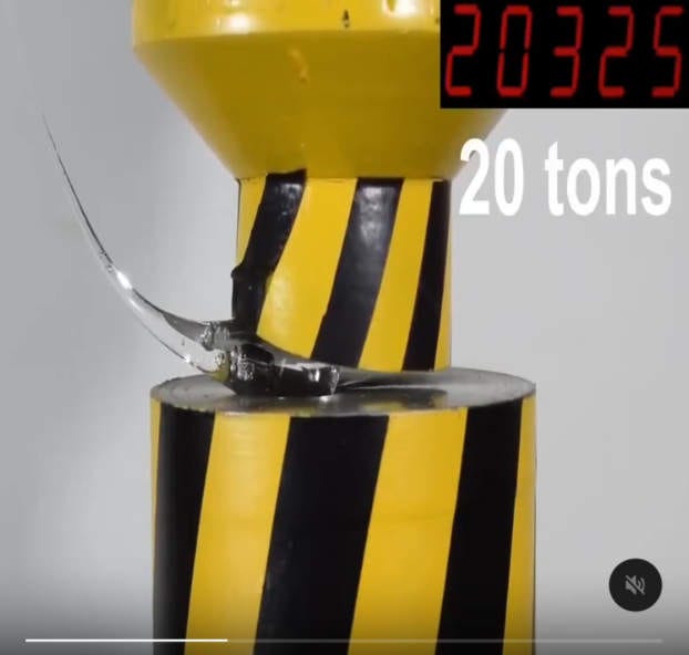 A hydraulic press pushing down on a droplet of glass and, incredibly, the press itself is deforming under the pressure!