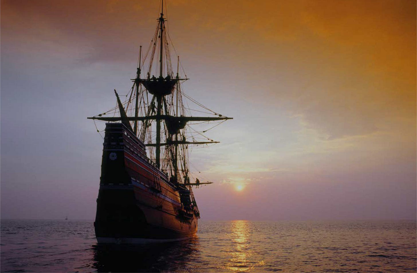 The Mayflower (replica) sails into a setting sun.