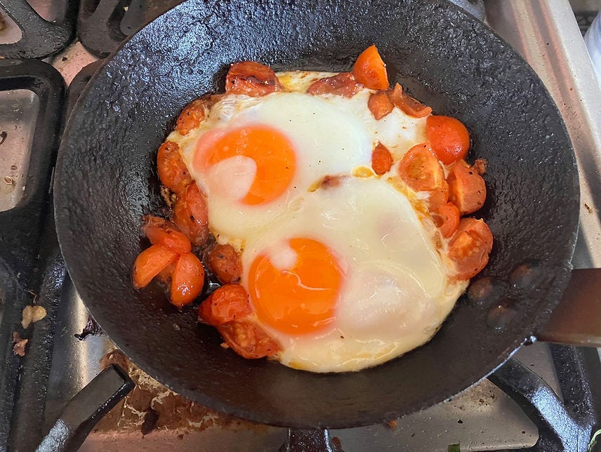 Eggs with caramelised tomatoes in a cast-iron pan