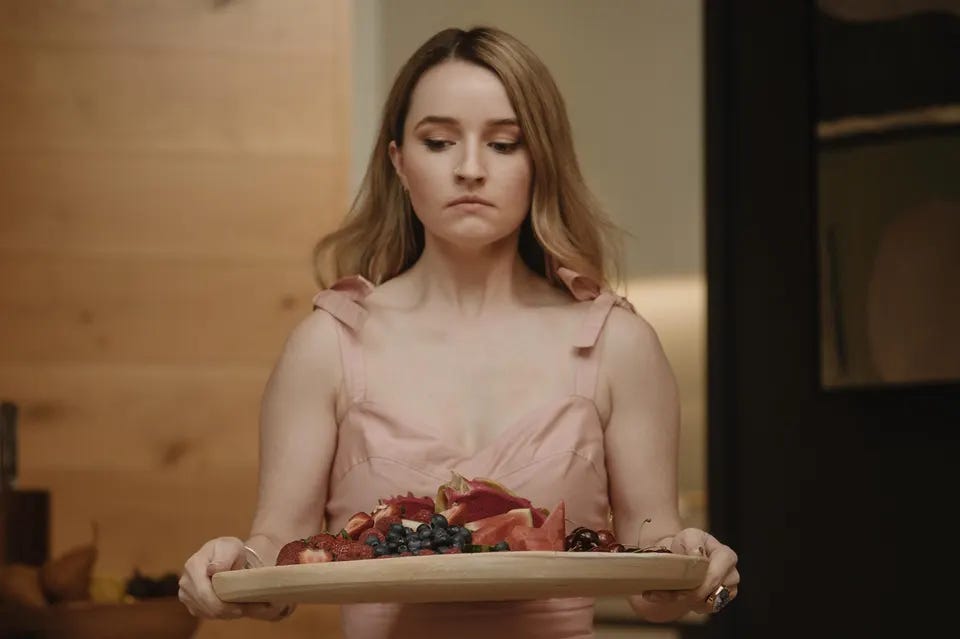 Kaitlyn Dever carries a platter of fruit in Apple Cider Vinegar.