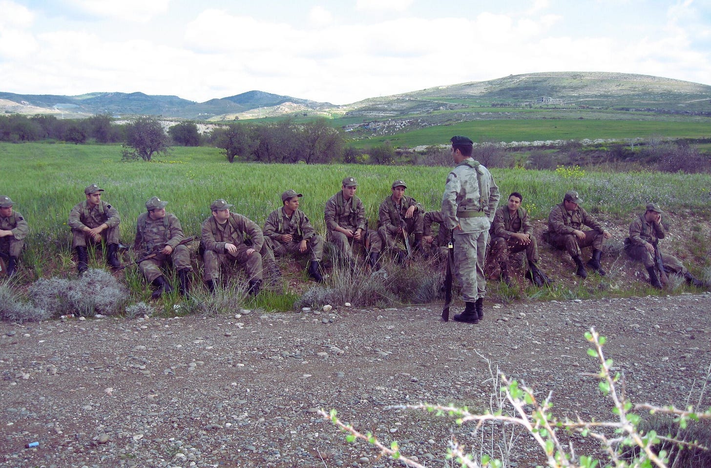 soldiers sitting in the grass in the foothills