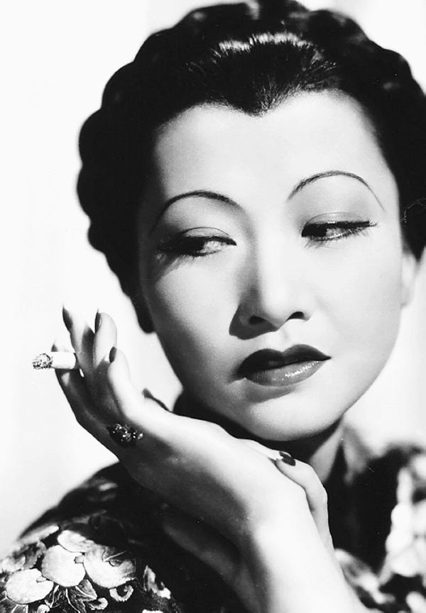 portrait of Anna May Wong holding a cigarette in her hand