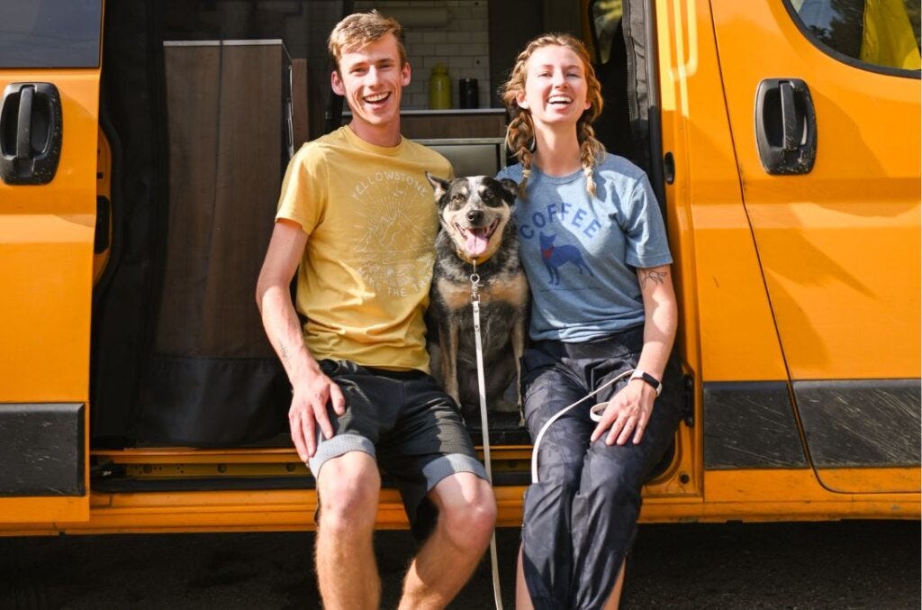 Sean, Scout, and Haley sit on the step of their converted camper van's open sliding door