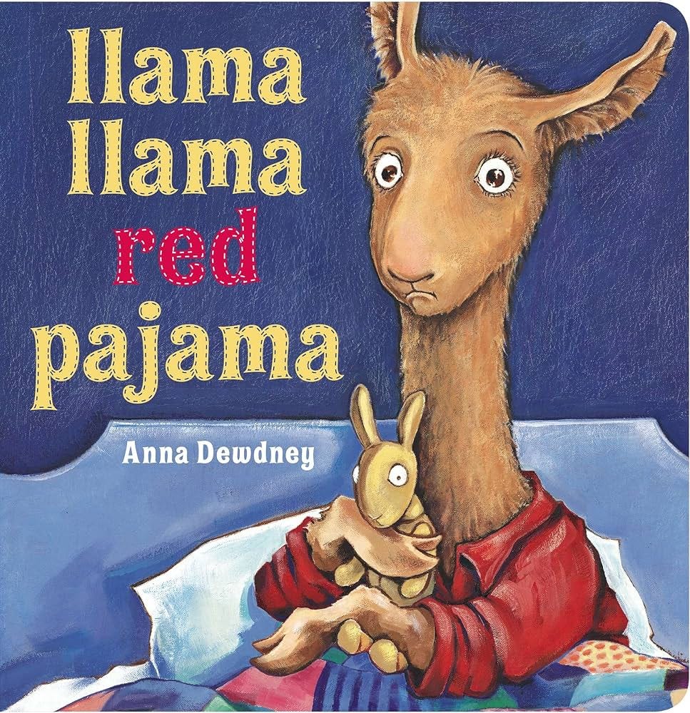   This book shows a blue background with a llama holding a baby stuffed kangaroo while in bed.            Este libro muestra un fondo azul con una llama sosteniendo un canguro de peluche mientras está en la cama.