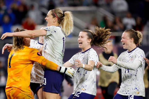 Alyssa Naeher of the United States is swarmed by teammates including Lindsey Horan, Emily Sonnett, and Tierna Davidson after defeating Canada in the...