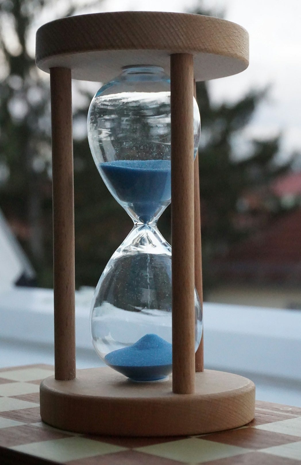 an hourglass sitting on top of a checkered table