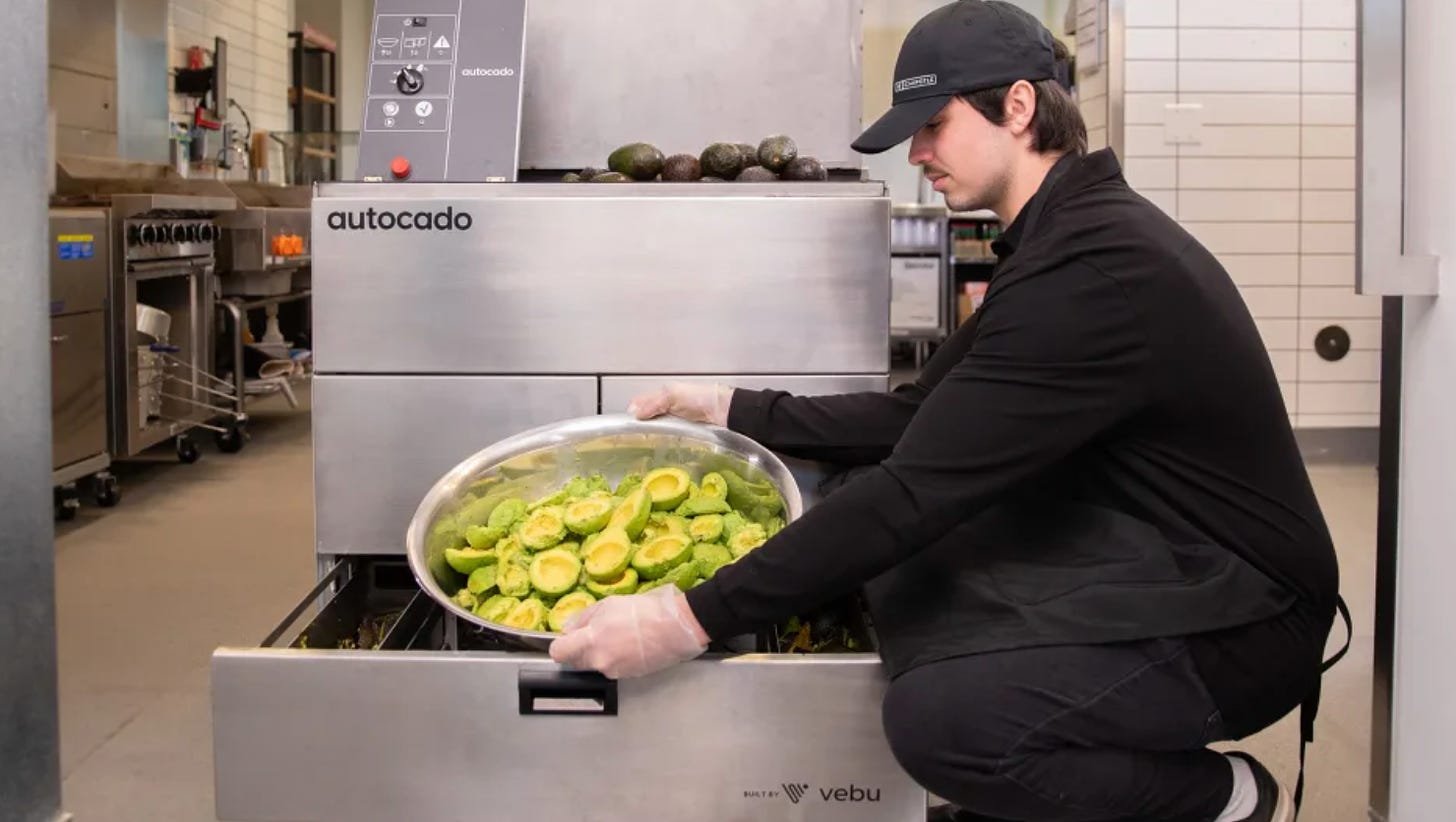 A guy loading avocados into a big machine with the word "autocado" on it