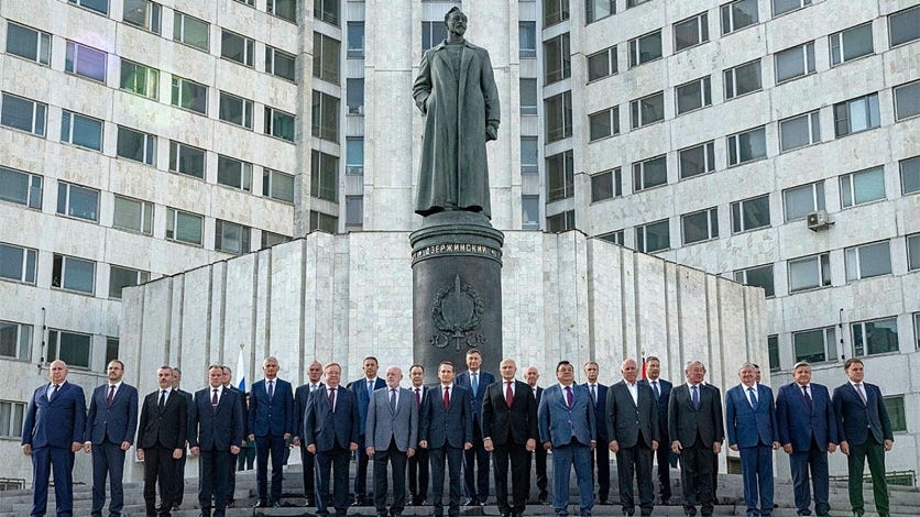 A group of men standing in front of a statue

Description automatically generated