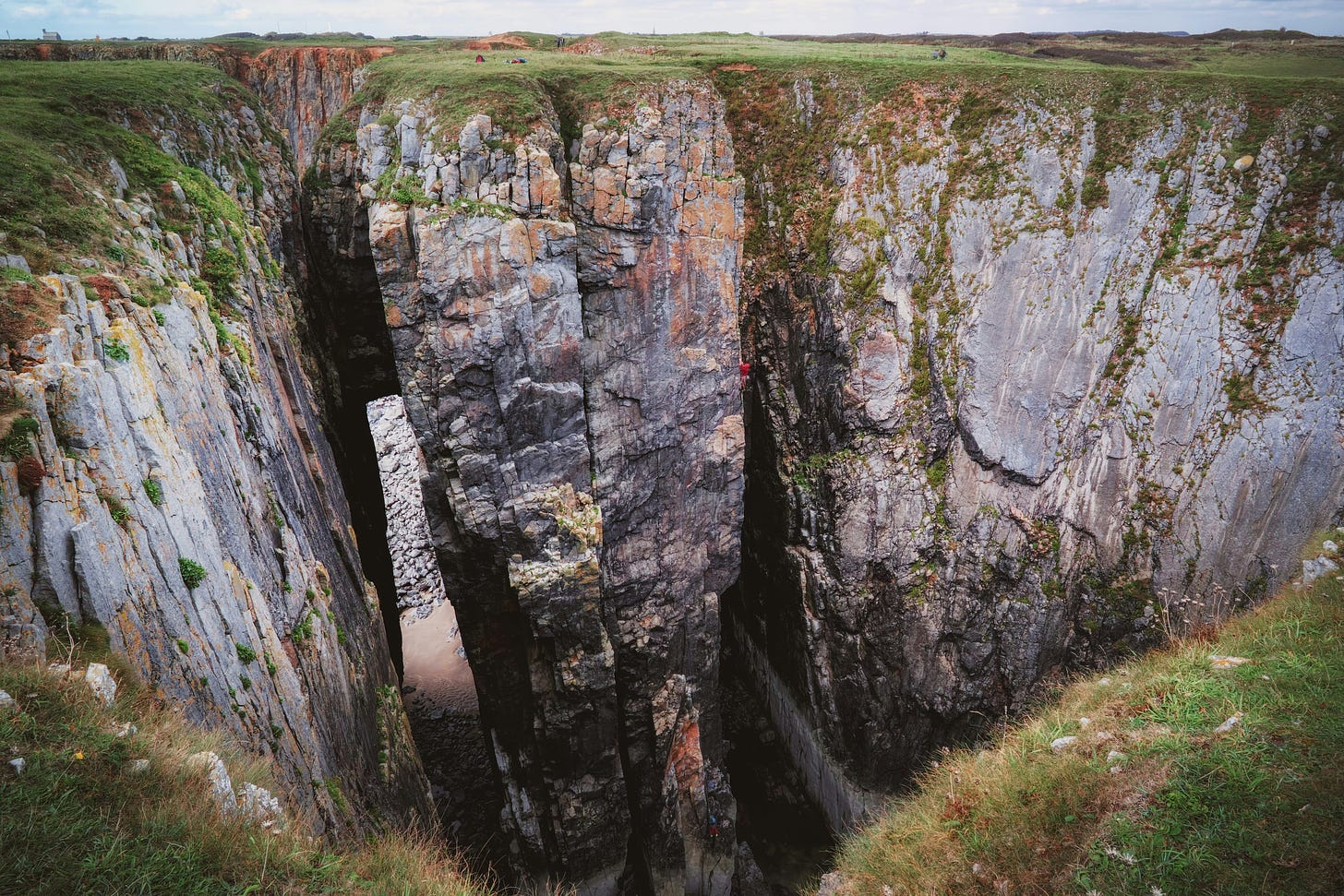 photo of sheer rocky cliffs with grass above and below, but no apparent way to jump the chasms that separate them