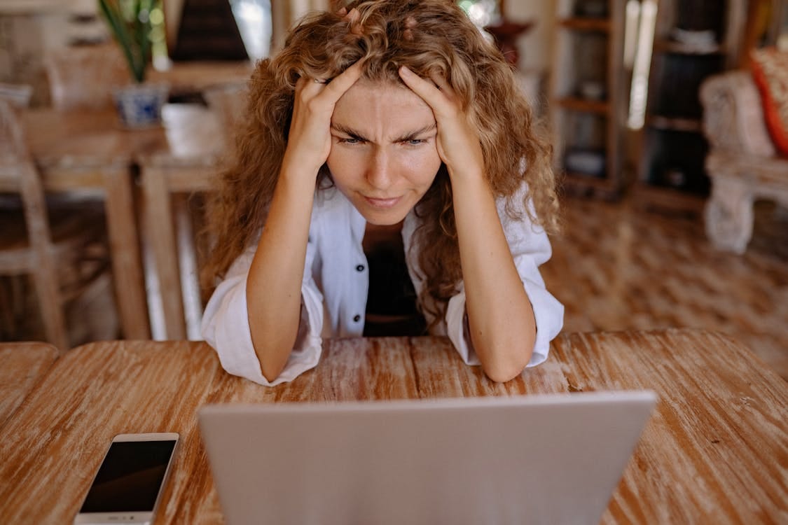 Free Photo of Woman Leaning on Wooden Table While Looking Upset Stock Photo