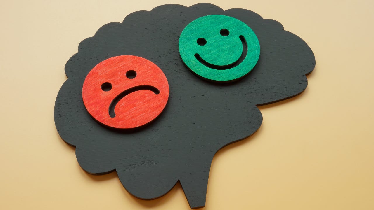 A green happy face next to a sad red face.
