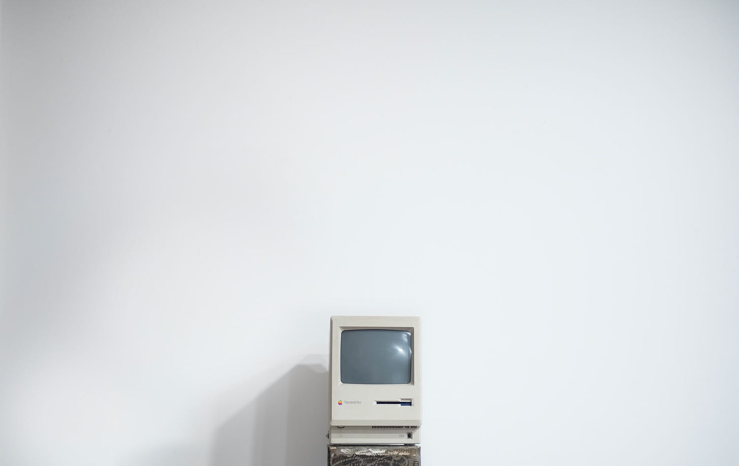 vintage Macintosh computer on blank white wall