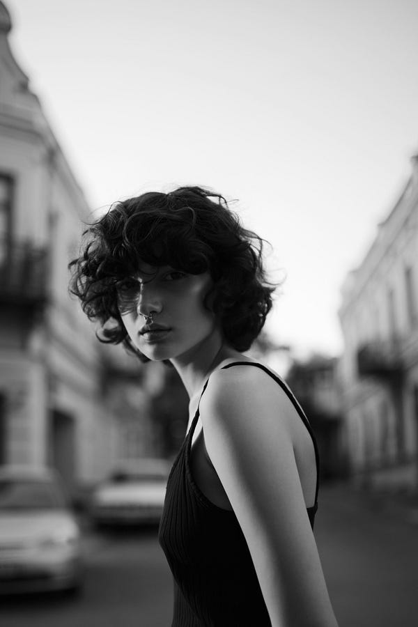 Woman with short hair looking at camera, Black and white photo.