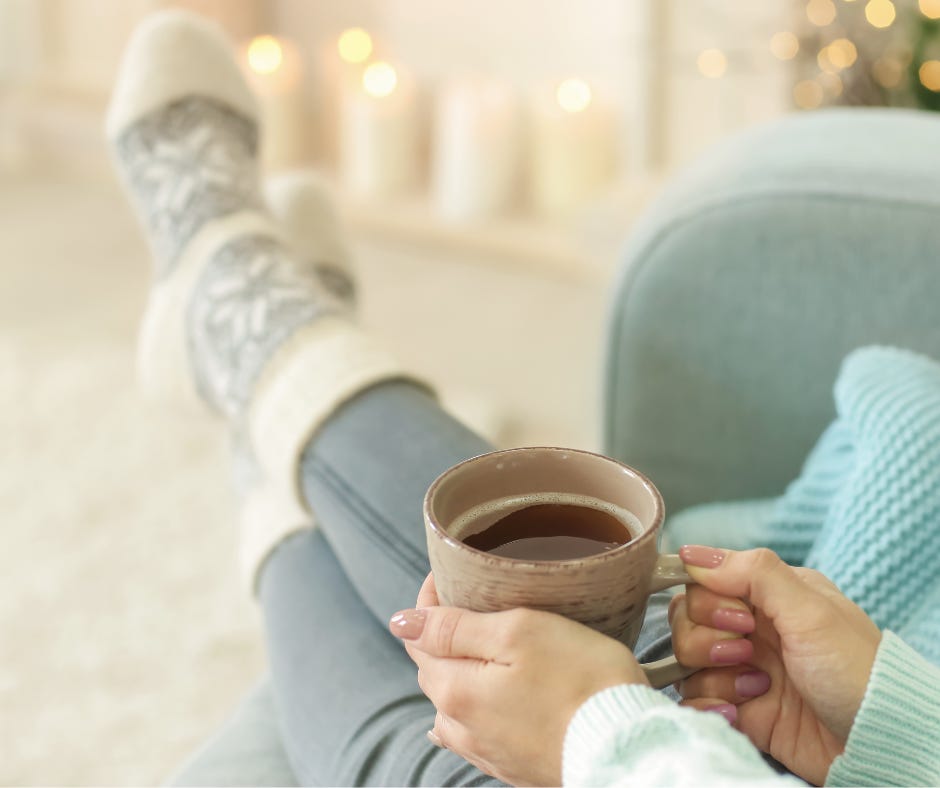 woman holding cup of coffee with her feet up wearing cozy socks