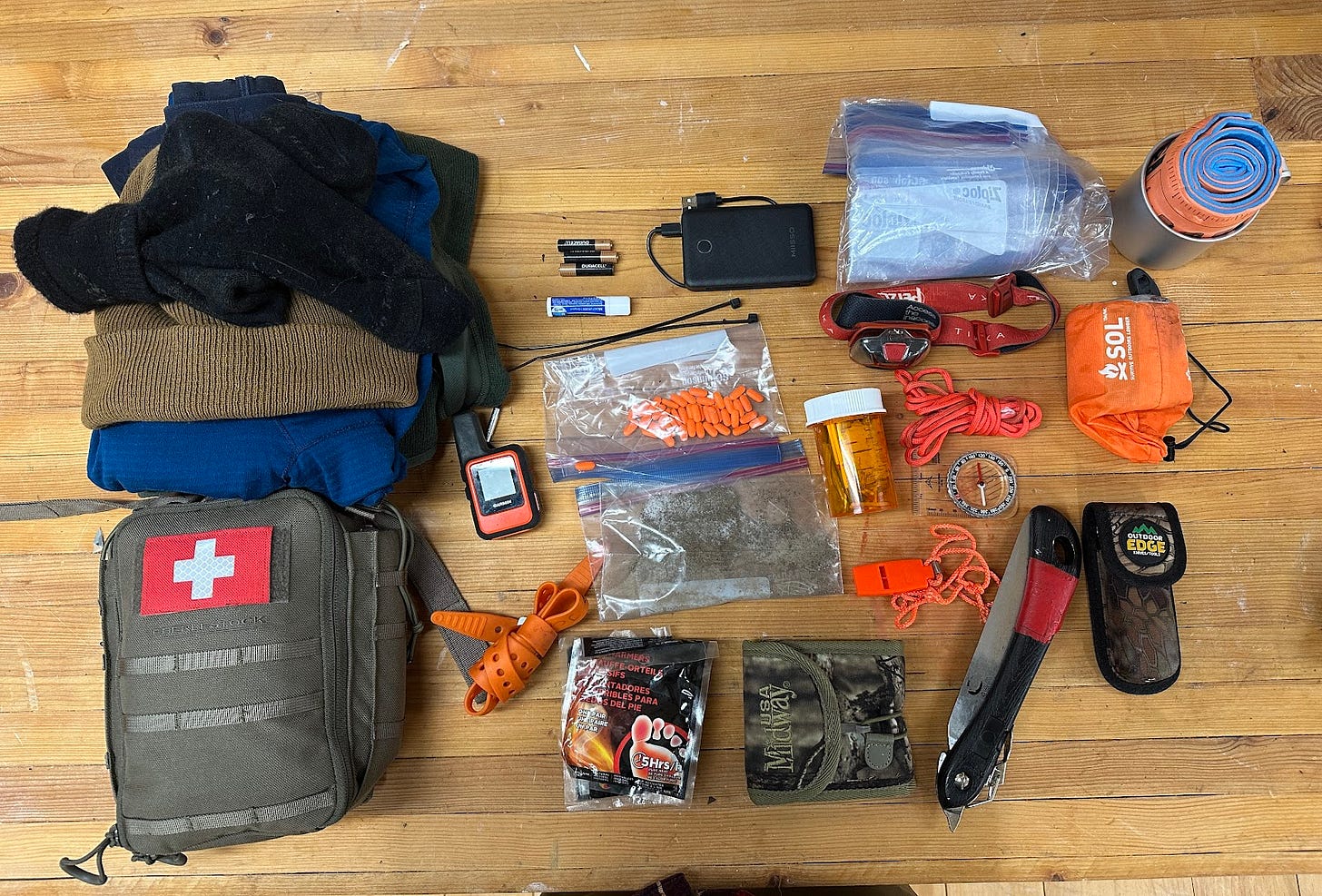 The contents of Jesse McEntee's Expedition-level survival kit spread out on the author's work bench.