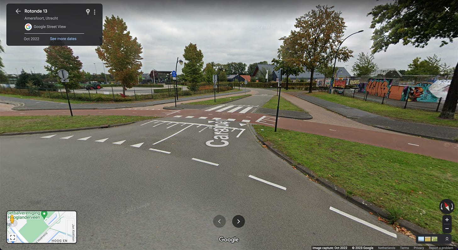 Entrance to a roundabout in the Netherlands with a raised crossing.