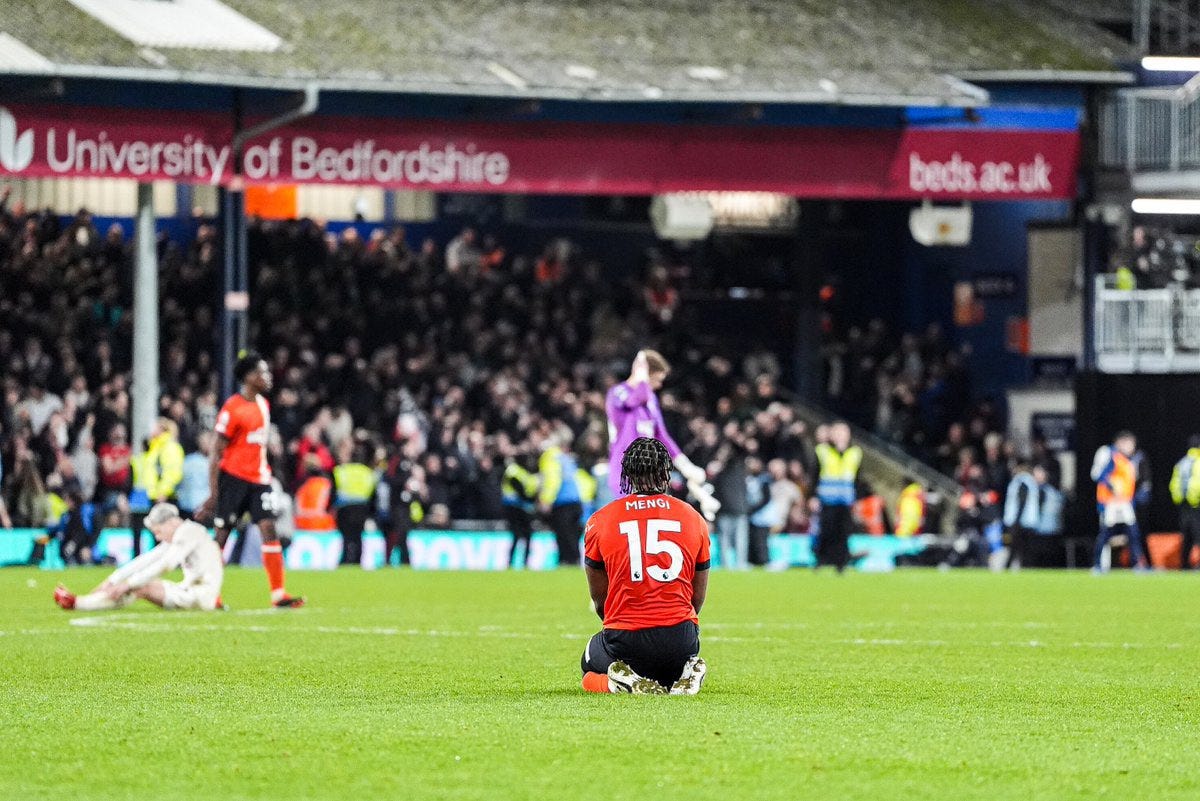 Teden Mengi on his knees looking towards the away fans at full-time.